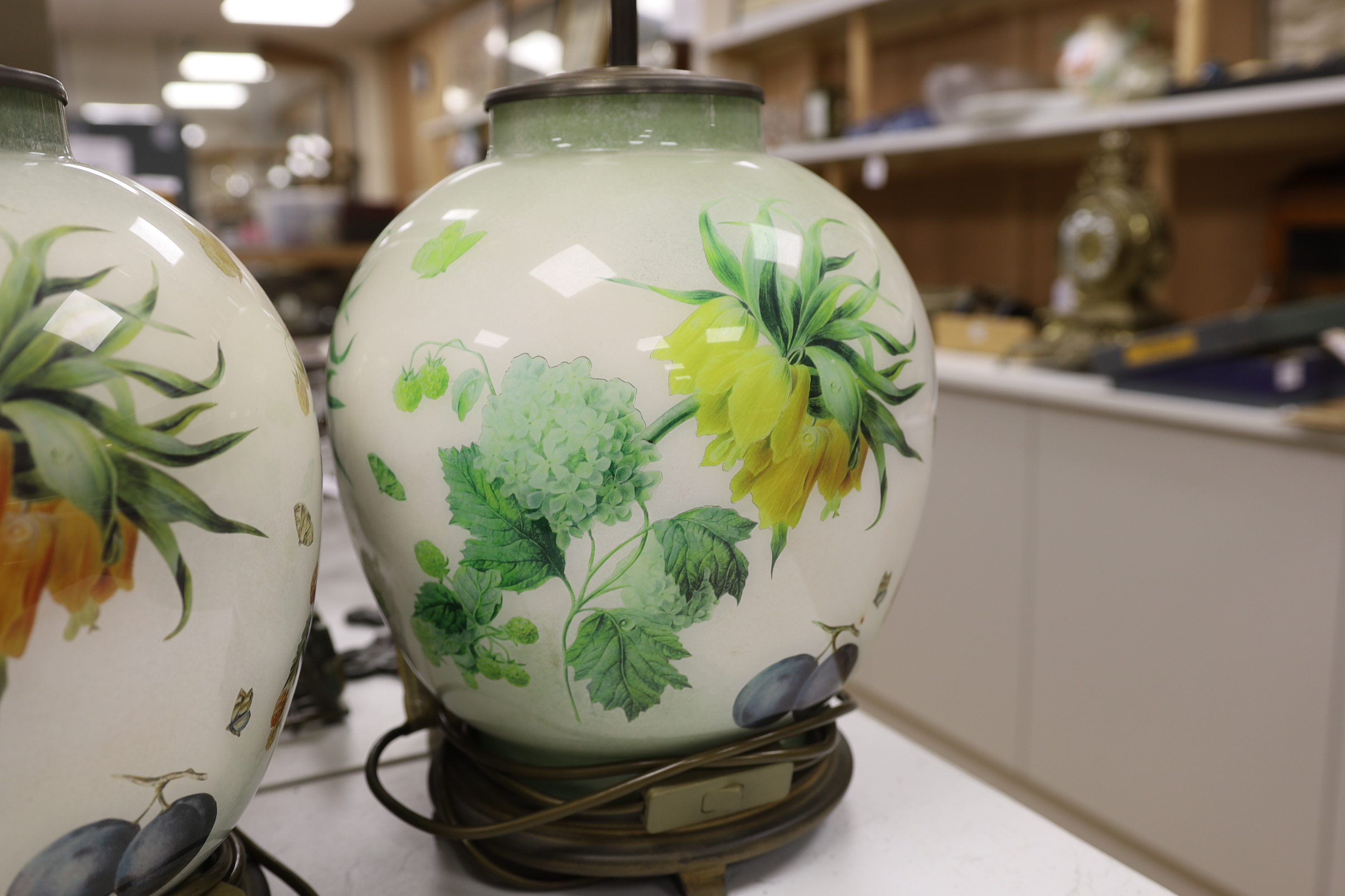 A pair of floral reverse decorated glass decorative table lamps and a similar crackle ware table lamp, 40cm not including light fitting